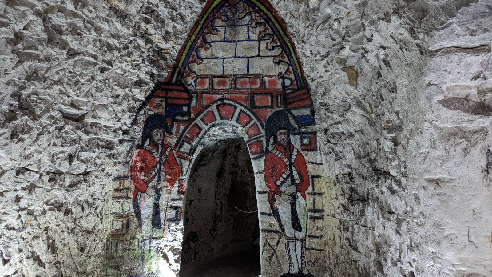 The long main tunnel with side cut away tunnels and figures drawn on the chalk walls.